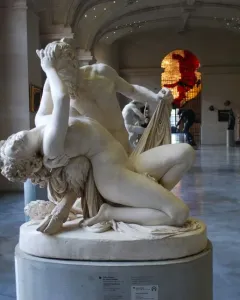 Satyre et bacchante marble sculpture showing two intertwined figures in a museum hall