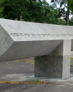 Klagebalken memorial with a long stone beam balanced on a central block outdoors.
