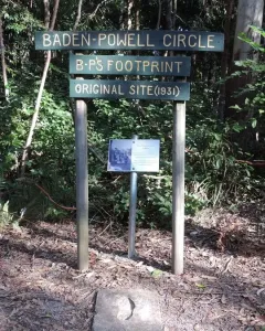 Concrete slab with a foot-shaped indentation beneath a Baden-Powell Circle signpost.