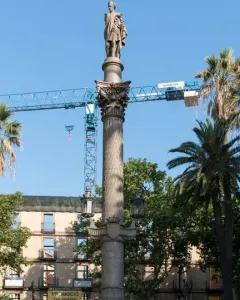 Galceran Marquet Monument with a stone column and standing figure, set in a fountain with bronze marine figures in Barcelona.