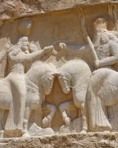Ardashir Investiture Relief showing two mounted figures facing each other with smaller figures behind them and forms beneath the horses.