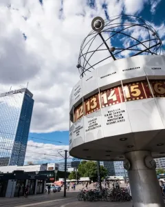 The World Clock in Alexanderplatz, a cylindrical public clock with city names and times beneath a globe structure.