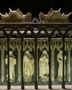 Tomb of Charles III and Eleanor with recumbent stone effigies, a lion at one figure\'s feet and two dogs at the other\'s, in a Gothic cathedral interior.