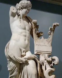 Apollo of Cyrene marble statue with a lyre-shaped support, missing its right arm and draped around the lower body.