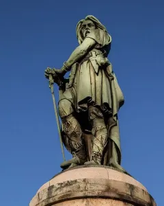 Vercingetorix Monument, a bronze warrior statue holding a sword against a blue sky