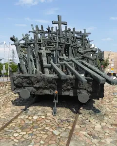 Monument to the Fallen and Murdered in the East, a dark sculpture shaped like a railway flatcar covered with crosses and beam-like forms