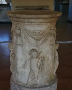 Four Seasons Altar with carved marble reliefs, draped swags, and putti holding flowers and grapes.