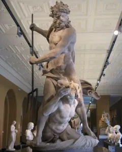 Neptune and Triton marble sculpture showing Neptune holding a trident over a kneeling Triton in a museum hall.