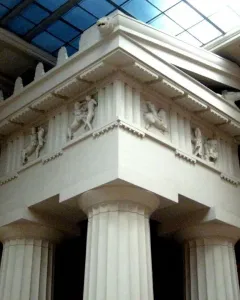 Parthenon metopes with marble relief figures in a battle scene beneath a glass ceiling.