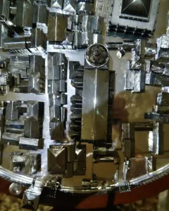 Gioiello di Vicenza shown as a circular miniature architectural model with many small metallic buildings and structures.
