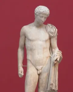 Hermes of Aegium, a light-colored marble statue of a nude male figure with a draped cloth over one shoulder and arm, standing against a dark red background.
