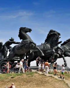 Legendary Tachanka bronze monument with four horses pulling a cart and figures, including one holding a flag.