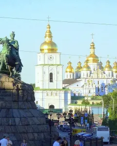 Monument to Bohdan Khmelnytsky on horseback with a cathedral and golden domes in the background.