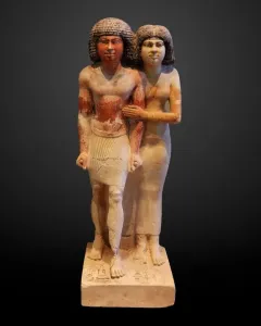 Raherka and Meresankh limestone statue showing a standing Egyptian man and woman together on a base.