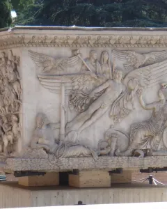 The marble base of the Antoninus Pius Column with detailed relief scenes, including a winged apotheosis panel and a procession of figures.