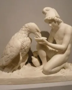 Ganymede with Jupiter\'s Eagle marble sculpture of a kneeling young man offering a dish to an eagle.