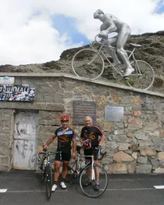 Géant du Tourmalet statue of a naked cyclist on a bicycle beside two cyclists and a Tourmalet sign