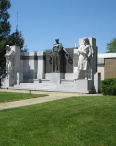 The Soldiers\' Monument, a stone and bronze memorial with two standing figures and a central bronze figure holding wreaths.