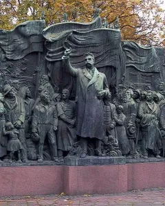 The Branting Monument in bronze, showing a central figure with a raised arm addressing a crowd of men, women, and children.