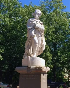 George Washington marble statue in military attire standing on a pedestal