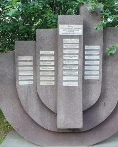 The Pit memorial with textured stone slabs and small plaques set in a grassy area.