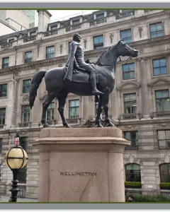 The Duke of Wellington equestrian monument on a granite pedestal in front of a stone building.