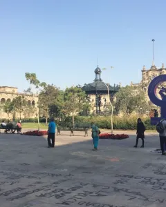 Antimonumenta, a large purple feminist symbol with a raised fist, stands in a public plaza covered in graffiti-like markings.