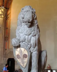 Marzocco, a seated stone lion with its paw on a shield decorated with a fleur-de-lis.