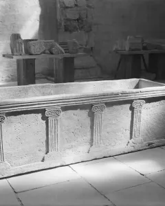 Sarcophagus of Louis the German, a rectangular stone chest with carved pilasters and Ionic-style capitals inside a museum space.