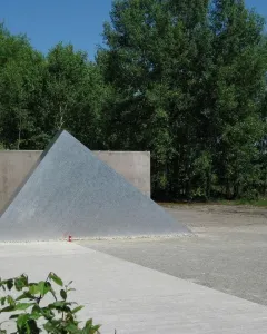 Hailfingen-Tailfingen Memorial with a textured triangular metal sculpture in front of a concrete wall.