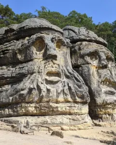 Devil\'s Heads carved into sandstone rock formations beneath a clear blue sky.
