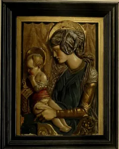 Painted terracotta relief of Madonna and Child with halos, the woman in blue and gold holding a child in red against a gilt background.
