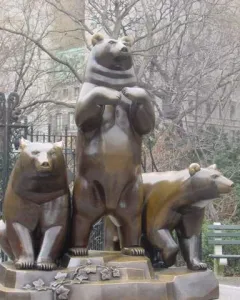 Group of Bears sculpture with three bear figures on a decorative base in a park.