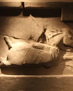 Stone relief of a horse from the Six Steeds of Zhao Mausoleum, shown in profile with its head raised and a harness visible.