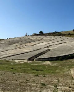 Il Grande Cretto with pale grey concrete slabs broken by deep angular fissures on a hillside