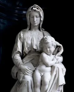 Madonna of Bruges, a white marble sculpture of a seated woman holding a nude child between her knees.