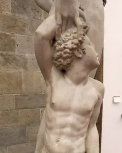 Marble sculpture of Apollo and Hyacinth showing a standing nude male figure and a kneeling figure beside him.
