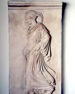 Gradiva relief showing a female figure in profile walking with one foot raised and draped in flowing garments.