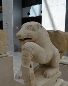 Bear of Porcuna stone sculpture showing a seated animal with one paw resting on a carved human-headed pillar.