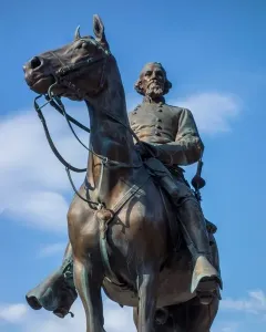Nathan Bedford Forrest Monument, a bronze equestrian statue of a bearded man in military uniform against a blue sky.