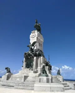 Antonio Maceo Monument with a bronze equestrian statue on a tall stone base decorated with bronze reliefs and figures.