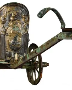 The Monteleone Chariot with ornate bronze relief figures and a central mask-like design on the front panel.