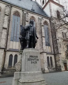 New Bach Monument: a bronze statue of Johann Sebastian Bach on a stone pedestal in front of a church.