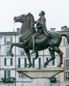 The Regisole equestrian statue stands on a stone pedestal in a city square in Pavia.