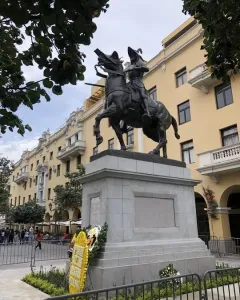 Francisco Pizarro equestrian statue mounted on a tall stone pedestal, with a floral wreath at its base.
