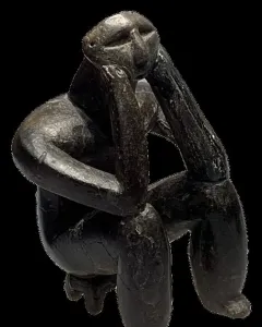 The Thinker of Cernavodă sculpture in a hunched seated pose with one hand supporting its head.