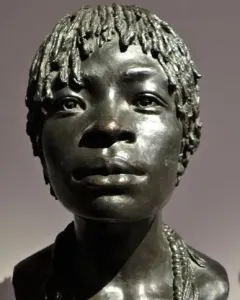 Woman of Central Africa bronze bust with short textured hair and layered beaded necklaces, shown in three-quarter profile.