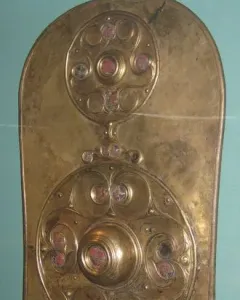 The Battersea Shield with three vertical circular bosses decorated with swirling patterns and red and pale inlays.