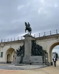 The Monument of Leopold II, a dark bronze equestrian statue on a stone pillar with sculptural figures at the base.
