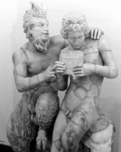 Pan and Daphne marble sculpture showing a bearded, horned figure embracing a nude youth holding a small musical instrument.